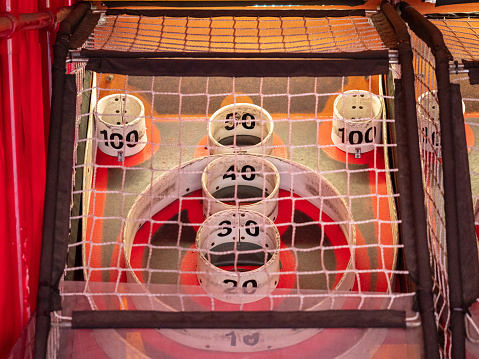 Scoring area of skee ball game behind a net with values of 100 to 10
