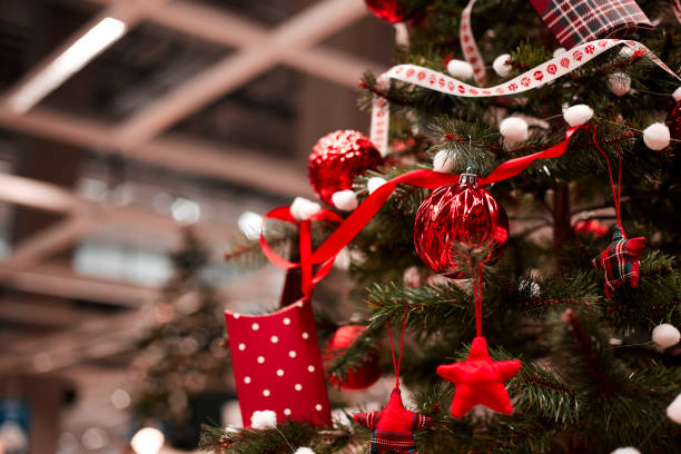 istock red bauble hanging from a decorated Christmas tree. 1063347854