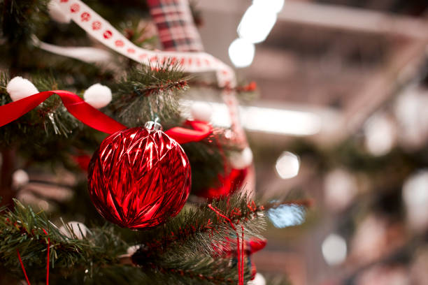 istock red bauble hanging from a decorated Christmas tree. 1063348422