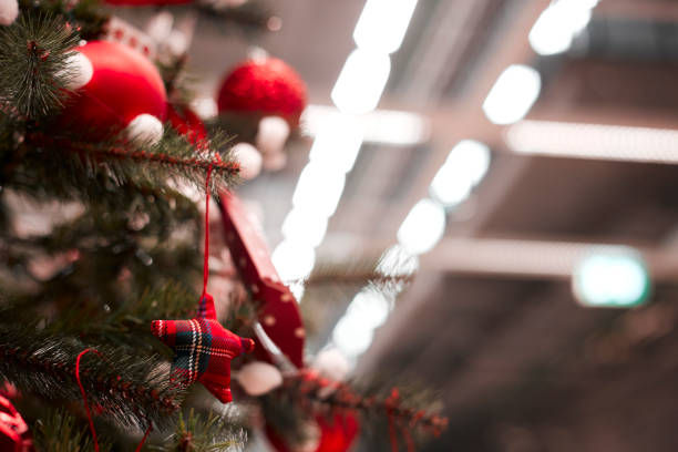 istock red bauble hanging from a decorated Christmas tree. 1063348900