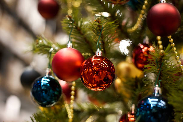 istock red bauble hanging from a decorated Christmas tree. 1063348966