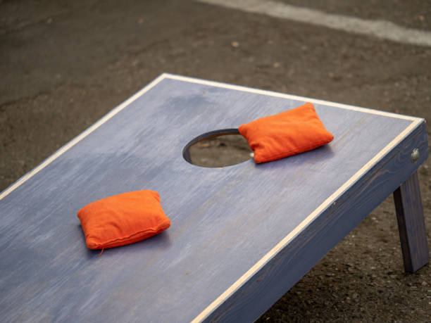 poufs orange assis sur la plateforme de conseil cornhole bleu - cornhole leisure games outdoors color image photos et images de collection