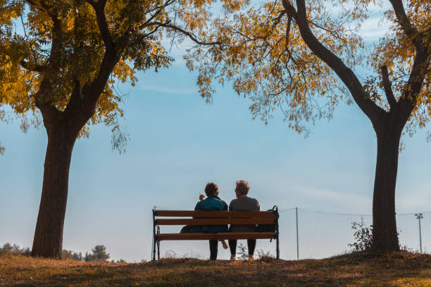 istock Two friends talk at the bench in the park 1063361766