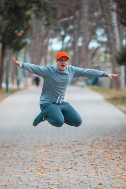 istock Young boy with red hat jumping in to the air 1063361826