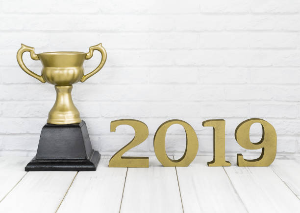 istock 2019 new year and golden trophy on white wood table over white background with copy space , winner or success concept 1063363206