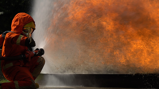 Fireman using fire hydrant to stop a flame. They use many styles of water to stop burning.