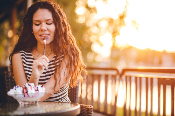 istock Woman eating ice cream by the riverbank 1063367366