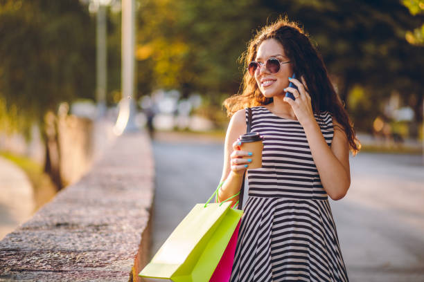 istock Woman with shopping bags using phone 1063367680