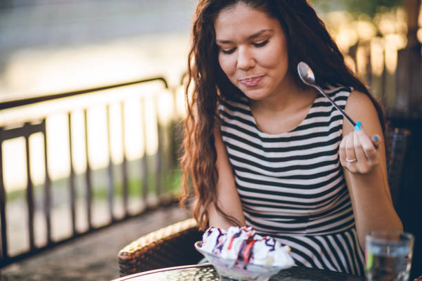 istock Woman eating ice cream by the riverbank 1063368024