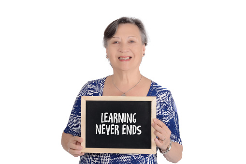 Elderly woman holding chalkboard with text 