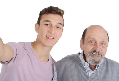 Grandfather and their teen grandson taking a selfie. Isolated on white background