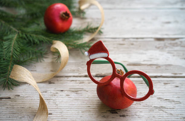 vivaci bicchieri da spettacolo di melograno di natale rosso con cornice decorativa per le vacanze e rami di abete su sfondo rustico in legno grigio. capodanno natalizio stendere il concetto di occhio guaritore. spazio di copia - deco decoration christmas christmas tree foto e immagini stock