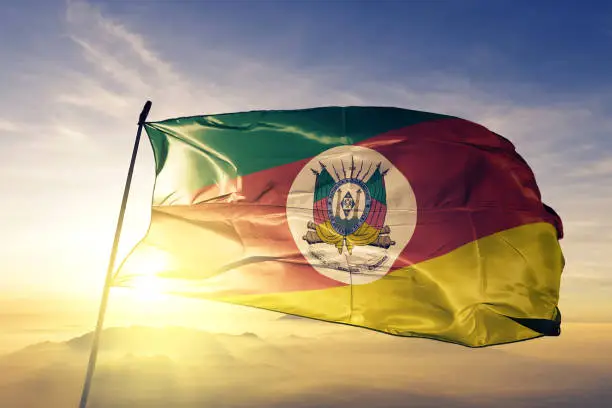 Photo of Rio Grande do Sul state of Brazil flag textile cloth fabric waving on the top sunrise mist fog
