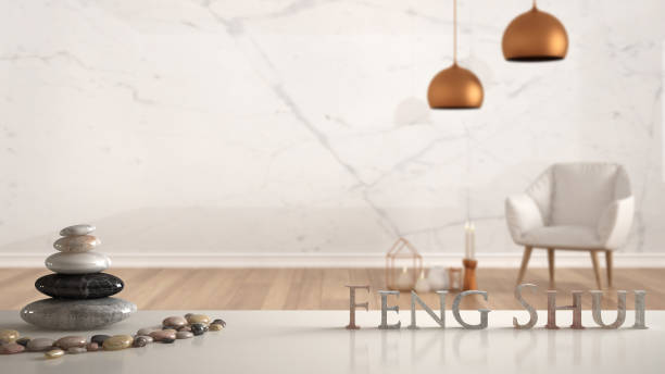 istock White table shelf with pebble balance and 3d letters making the word feng shui over empty room with marble wall, white armchair, candles and decor, zen concept interior design 1063375504