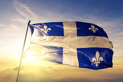 Quebec provincia de Canadá textil tela tela de la bandera ondeando en la niebla de la niebla de amanecer superior photo