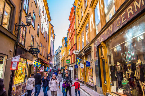 stockholm streets with touristsin  Gamla Stan,The Old Town in Stockholm, Sweden The main shopping street in gamla stan also know as old town of stockhom. The street is full of tourists and colorful shops. The pic is taken in bright sunny day and the gamla stan is full of people and tourists. stortorget photos stock pictures, royalty-free photos & images