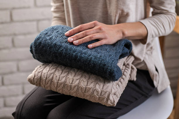 istock Woman's hands holding knitted clothes. Close up. 1063378494
