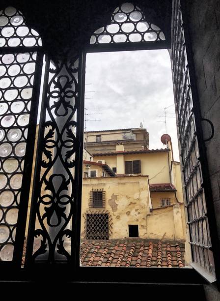 istock Ancient window with artistic glasses overlooking the city rooftops 1063385640