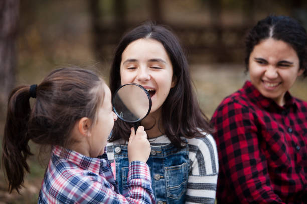 istock girls having fun with magnifying glass 1063387400