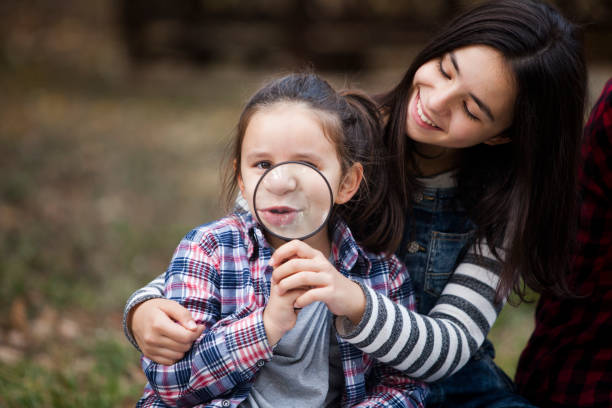 istock girls having fun with magnifying glass 1063390098