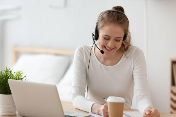 istock Cheerful woman wearing headset with microphone working indoors 1063392606