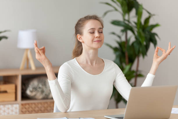 istock Woman meditating doing yoga sitting at workplace 1063392640