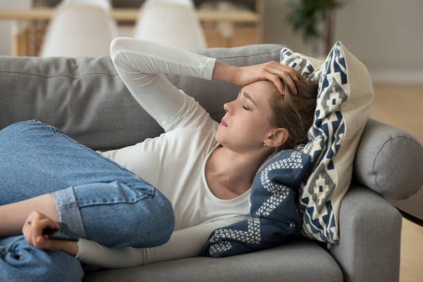 istock Unhappy woman lying on couch at home 1063392710