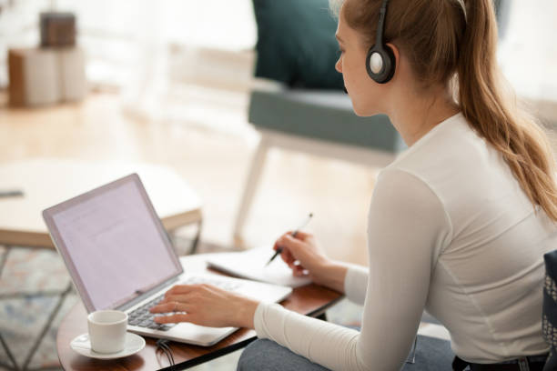 istock Woman wearing headset using laptop working or studying 1063392718