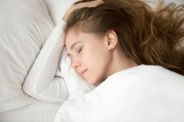 istock Woman lying in bed and sleeping at home 1063392774