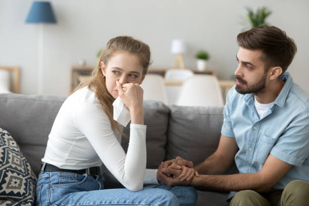 istock Girl crying sitting together with guy on couch at home 1063392802