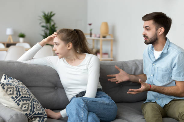 istock Couple quarrelling sitting on couch at home 1063392826