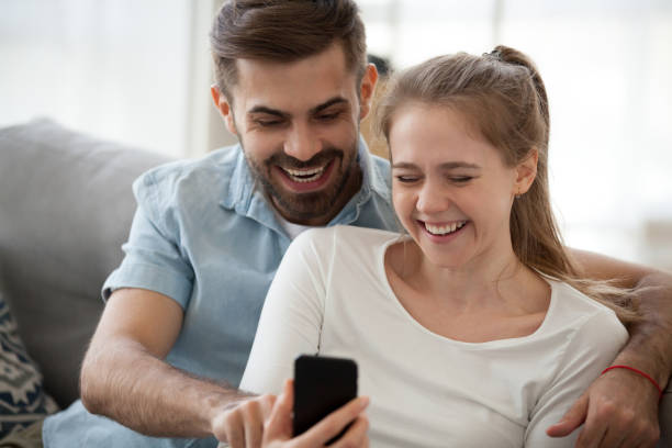 istock Couple sitting on couch using mobile phone 1063392832