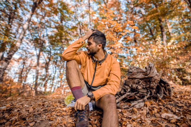 istock Hiker sitting on ground in woods in autumn. 1063393482