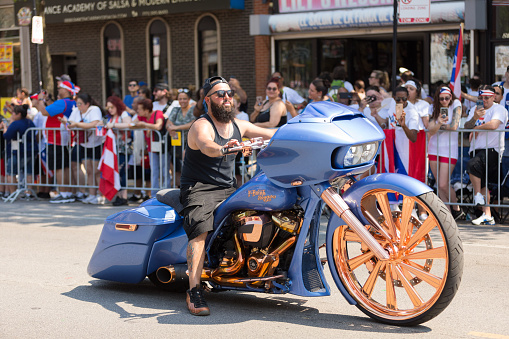 Chicago, Illinois, USA - June 16, 2018: The Puerto Rican People's Parade, Man riding a custom build motorcycle with large wheels and a sticker that says F-Bomb Baggers