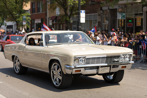 Chicago, Illinois, USA - June 16, 2018: The Puerto Rican People's Parade, Puerton rican people riding on cars celebrating with puerto rican flags