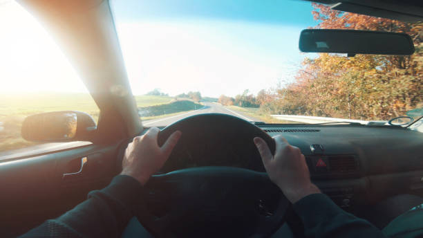 istock Man drives on a highway and the sun shines 1063399912