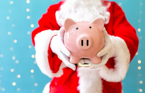 istock Santa holding a piggy bank 1063400404