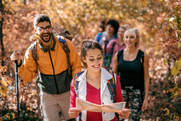 istock Woman leading other hikers in woods. 1063403514