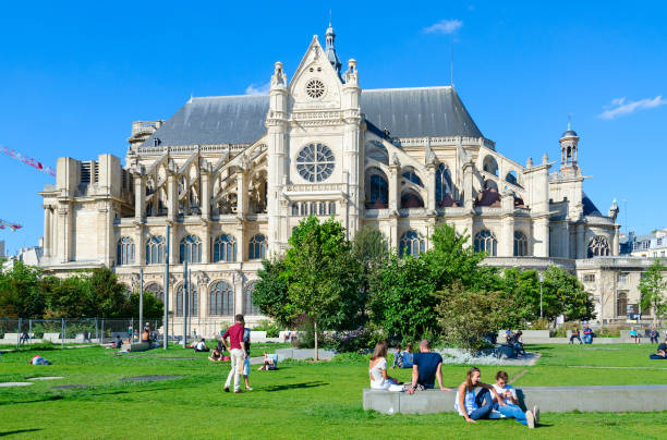 ludzie odpoczywają na zielonym trawniku w pobliżu kościoła katolickiego św eustache, lub saint-eustache (église saint-eustache), paryż, francja - église saint eustache zdjęcia i obrazy z banku zdjęć