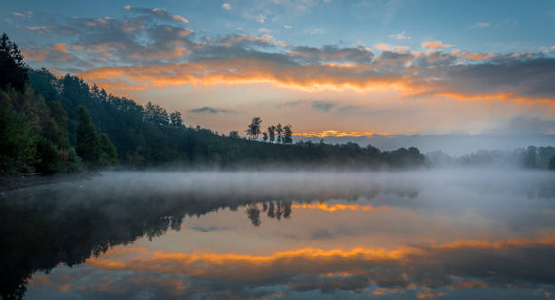 Enjoying natural wonders in the morning This photograph is taken at Lac de Robertville in Belgium. It was a true magical moment, with the mysterious mist above the water surface and the amazing colors in the sky. ardennes department france stock pictures, royalty-free photos & images