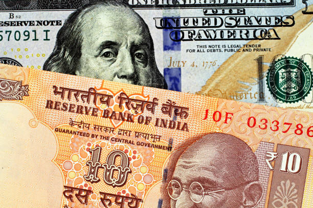 istock An Indian Ten Rupee Bank Note With An American One Hundred Dollar Bill 1063408734