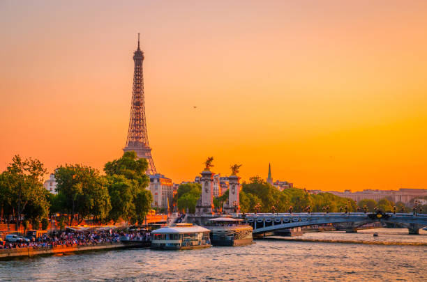 vista al tramonto della torre eiffel, del ponte alessandro iii e della senna a parigi, francia - paris france panoramic seine river bridge foto e immagini stock