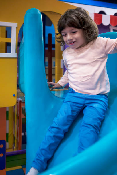 istock Smiling little Boy climbing and sliding on playground 1063421698