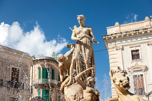 The Diana Fountain built in 1907 and surrounding buildings in the Archimedes square in the center of  Ortygia island in Syracuse, Sicily, Italy