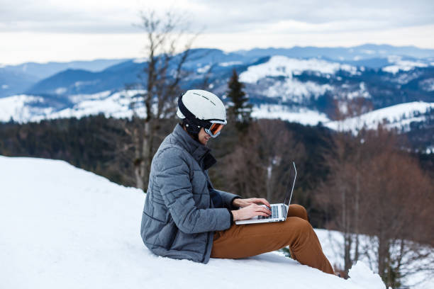 istock A young man with a gadget sitting at cliff edge, close up 1063423772