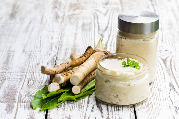 Spicy horseradish sauce in glass jar on wooden table Spicy  horseradish sauce in glass jar on wooden table horseradish stock pictures, royalty-free photos & images