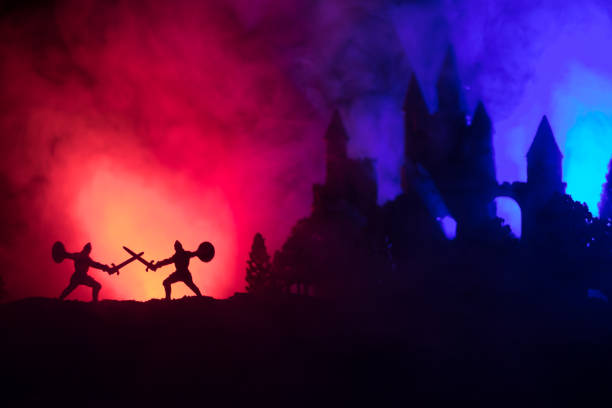 istock Silhouettes of figures as separate objects, fight between warriors on dark toned foggy background with old gothic castle 1063424706
