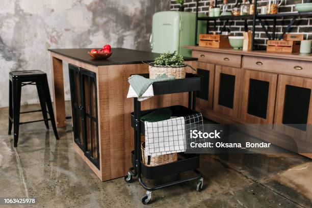 Cozy Loft Kitchen With Dinning Table Chairs And Metal Storage Racks On Wheels Trolley Stock Photo - Download Image Now