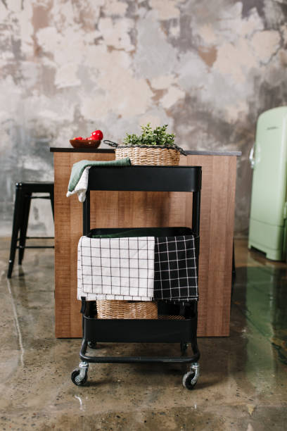 Cozy loft kitchen with dinning table, chairs and metal storage racks on wheels - trolley
