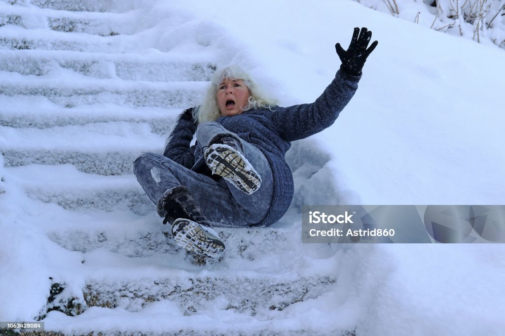 Una mujer resbaló y cayó en una escalera invernal. Caer en pasos suaves - Foto de stock de Caer libre de derechos